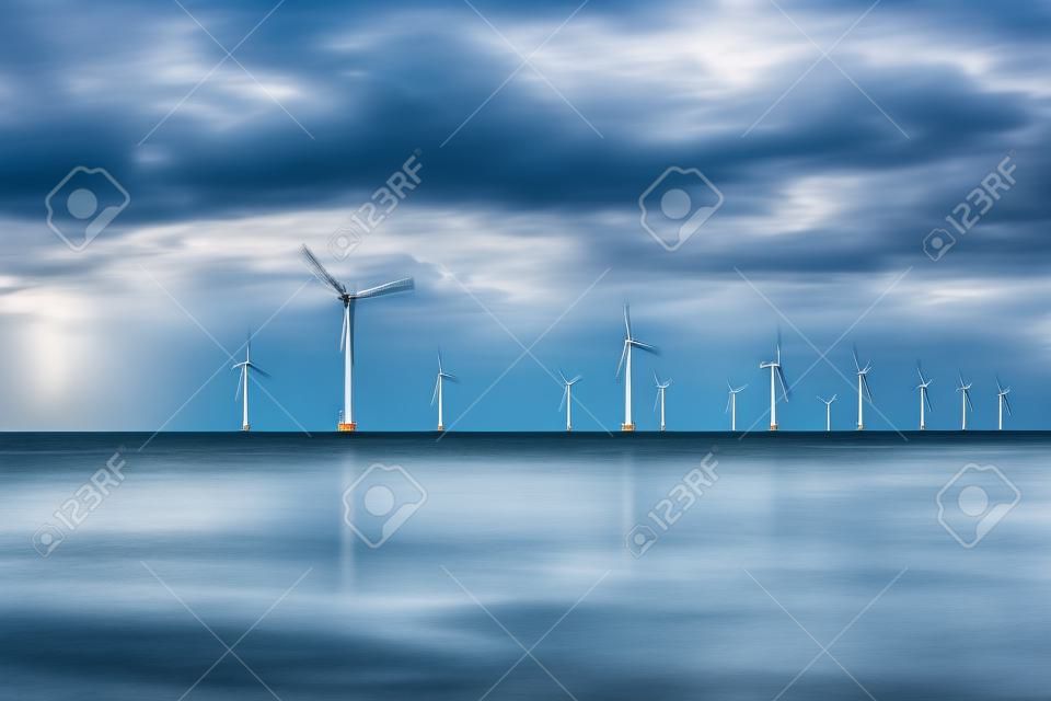 parque de moinhos de vento offshore com nuvens tempestuosas e um céu azul, parque de moinhos de vento no oceano.