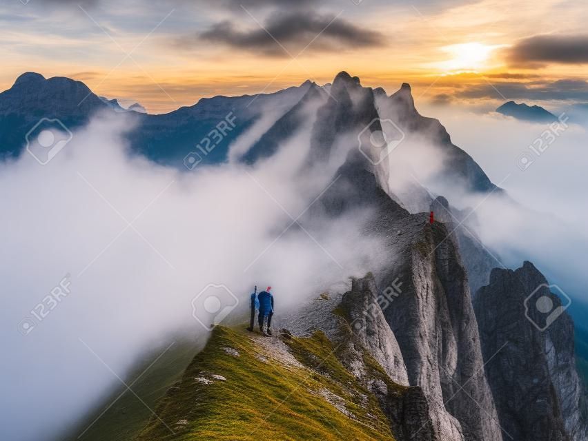 Schaefler Switzerland, a couple walking hiking in mountains during sunset, man and woman sunset at the Ridge of the majestic Schaefler peak in the Alpstein mountain range Appenzell,