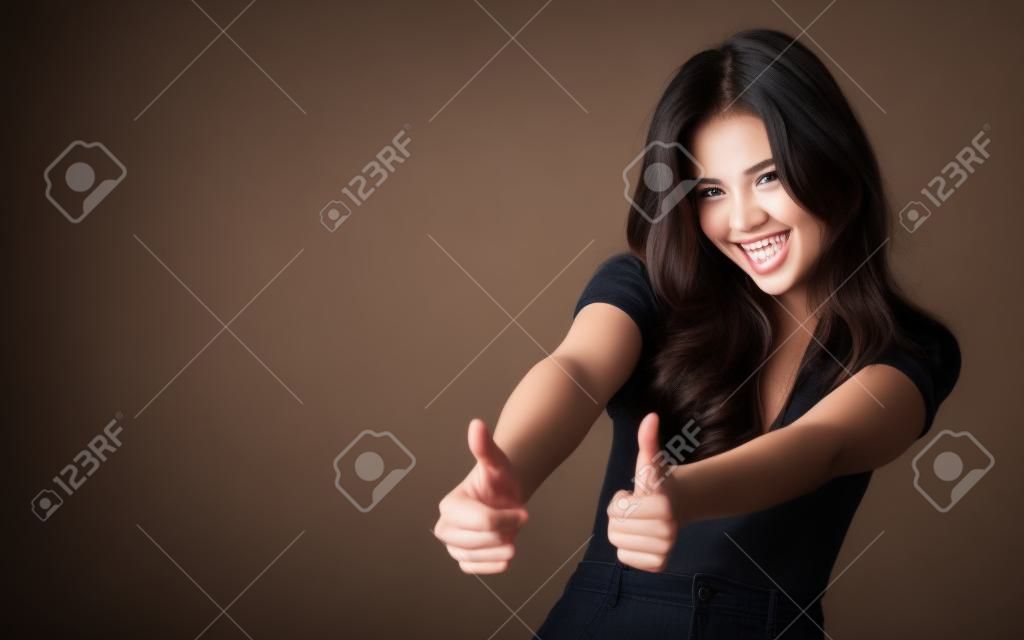 beautiful young model smiling and showing a gesture. Studio, dark background, energetic and beautiful model. luck and success