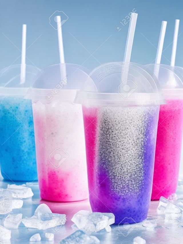 仍然在塑料冷凍水果雪泥格蘭尼塔飲料生命檔案外賣帶蓋杯子，喝與散亂冰塊冷金屬表面低溫秸稈