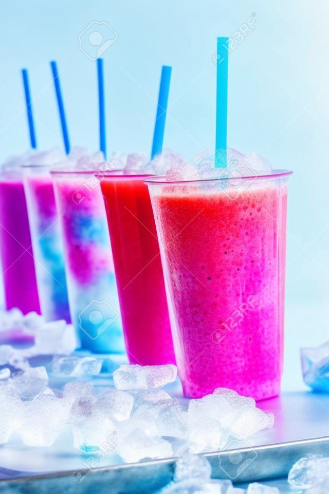儘管如此七彩冷凍水果格蘭尼塔雪泥飲料的生活中塑料外賣，在一排排列冷金屬表面吸管杯被冰塊包圍
