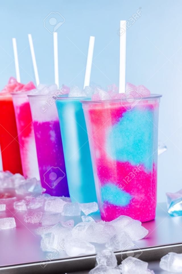 儘管如此七彩冷凍水果格蘭尼塔雪泥飲料的生活中塑料外賣，在一排排列冷金屬表面吸管杯被冰塊包圍