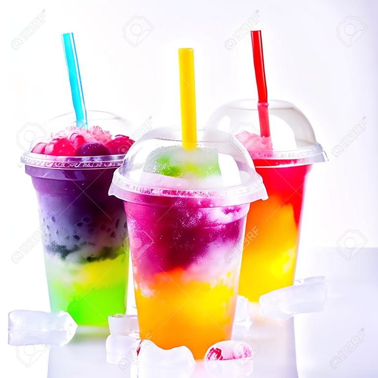 Still Life Close Up of Colorful Rainbow Layered Frozen Fruit Slush Drinks Arranged on Ice Covered White Surface in Plastic Take Away Cups with Drinking Straws - Trio of Refreshing Granitas