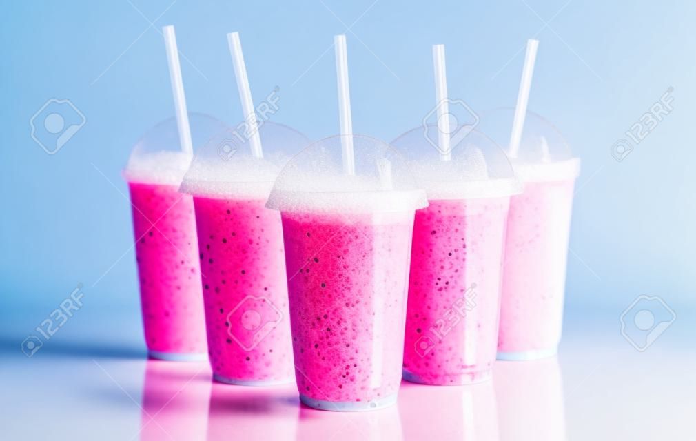 Ainda Vida Perfil de Frozen Fruit Slush Granita Bebidas em Plástico Tirar Copos com Tampas e Colheres Organizados na Superfície Refletiva na frente do Fundo Branco