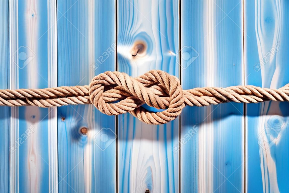Nautischthemenorientiertes Hintergrund - Erhöhte Stillleben von Doppel Acht-Knoten in Natur Seil über Blau Holz bemalt Plank Hintergrund mit Textfreiraum