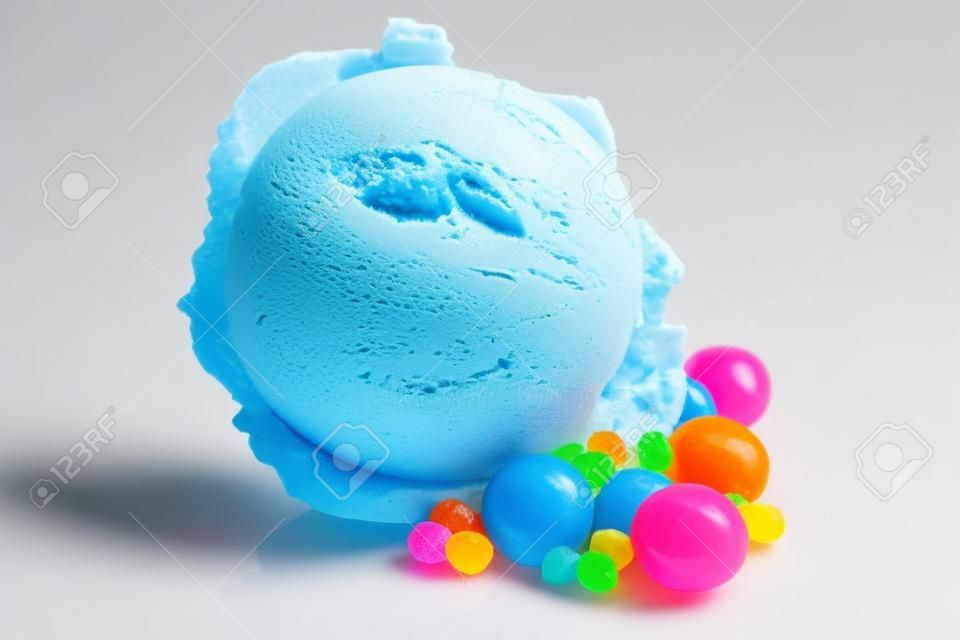明るい青いバブルガム風味アイスクリームの白地にカラフルなお菓子と 1 つのスクープの静物を閉じる
