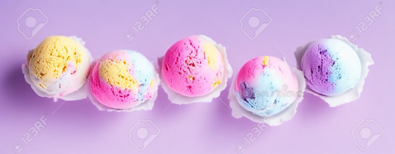 Alto ângulo ainda vida vista de cinco colheres de sorvete colorido e refrescante na frente do fundo branco