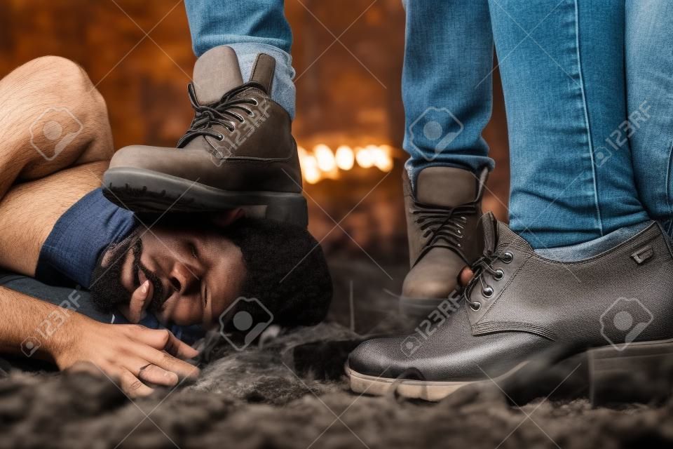 Nahaufnahme eines Mannes Fuß zerquetscht Mann den Kopf. Homophobe menschen