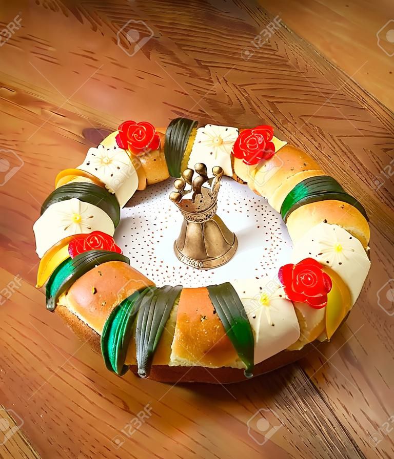 Torta di Epifania, torta di re, o Rosca de reyes con mangiatoia sul tavolo di legno
