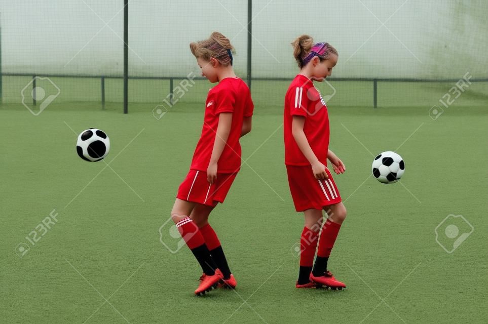 Two young girls playing soccer