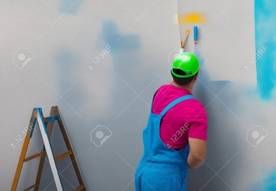 Jonge man op het schilderen muur met roller
