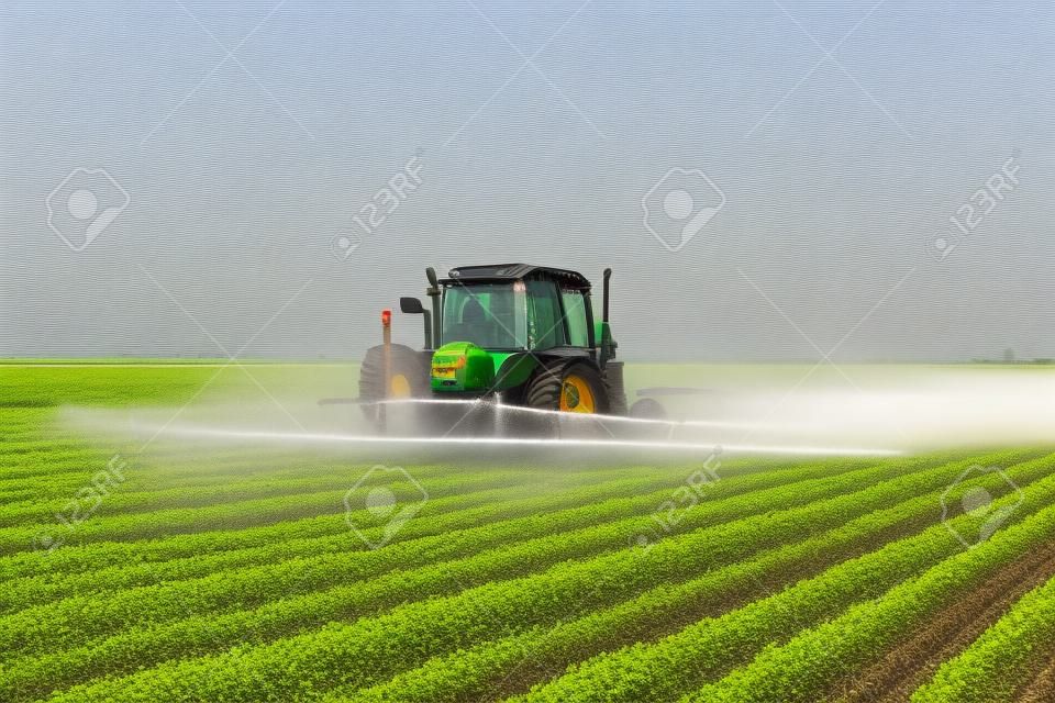 Tractor fumigación campo de soja en la primavera