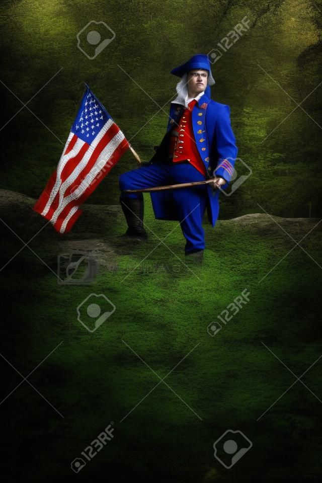 アメリカ独立戦争の兵士の衣装で、旗が森の中でポーズをとる男。米国コンセプト写真合成47月独立記念日