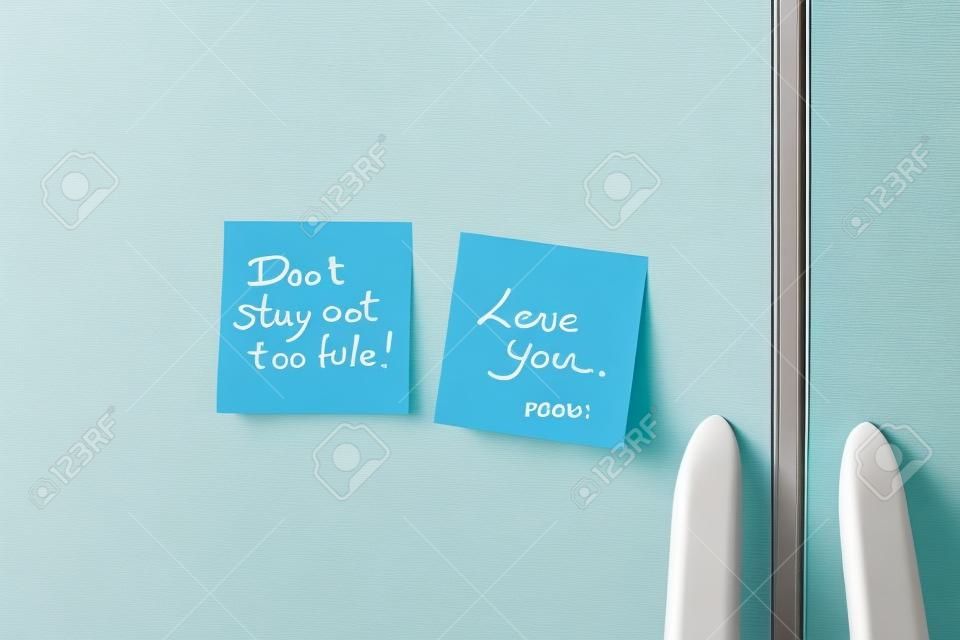 Friendly sticky notes on a kitchen refrigerator door in a home 
