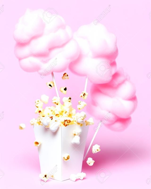 una ilustración de aperitivos dulces de algodón de azúcar y palomitas de maíz en una caja de cartón de color rosa sobre fondo blanco