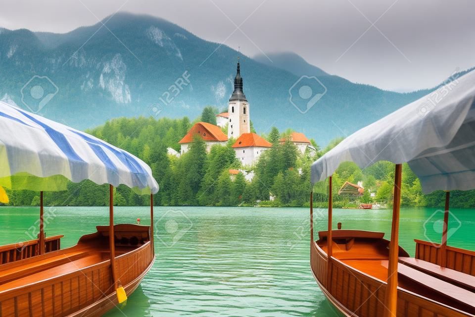 Bateaux typiques en bois, en slovène appelé "Pletna", dans le lac de Bled, le lac le plus célèbre de Slovénie avec l'île de l'église (Europe - Slovénie)