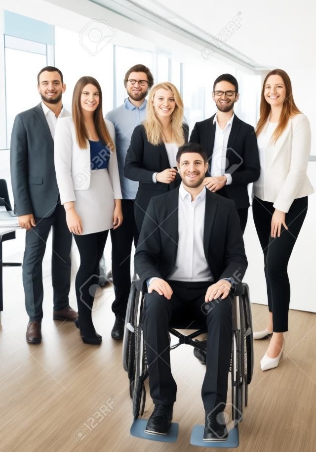 辦公室裡的一個業務團隊的肖像，坐在輪椅上的一個人，都很年輕 - 可能是一家創業公司