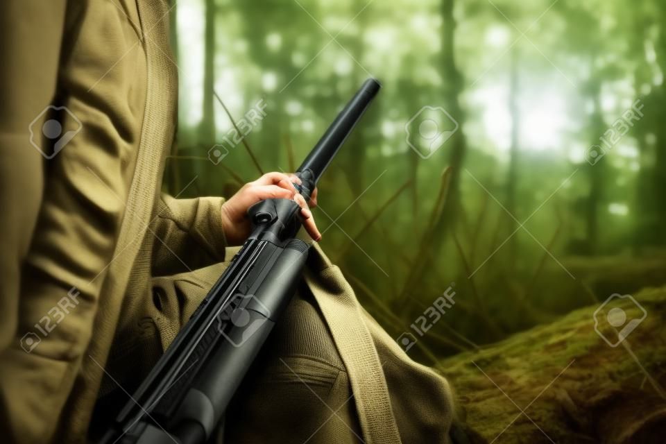 Polowanie. Myśliwy kobieta trzyma broń w lesie