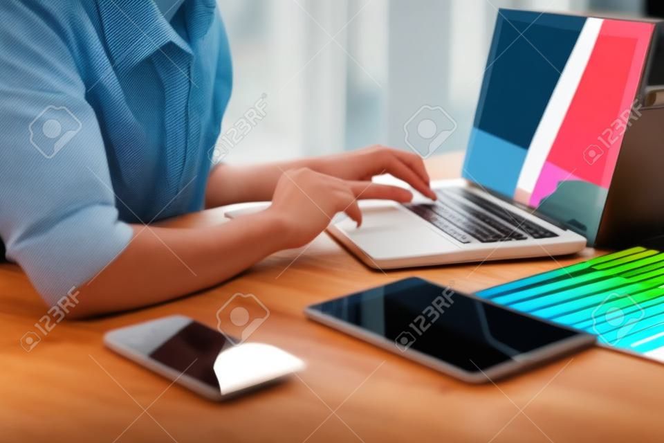 Kreativer kreativitätsgrafikdesigner, der mit grafiktablette, laptop und intelligentem telefon, farbtafel am arbeitsplatz auf hölzernem schreibtisch, farbideenartkonzept arbeitet.