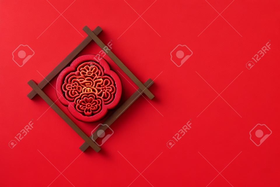 trendy flower shape mooncake on red background with copy space