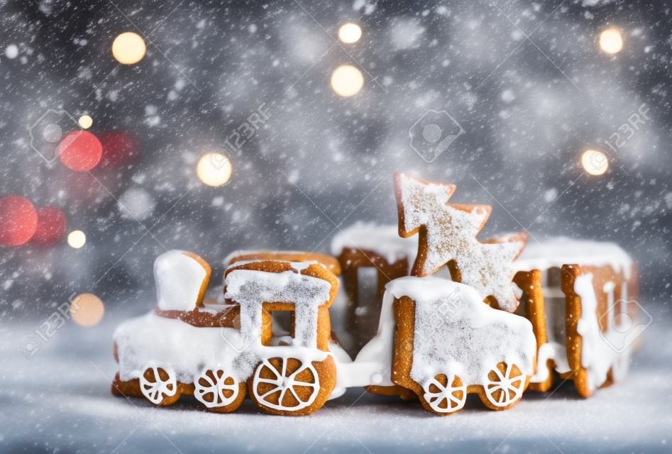 ngerbread Cookies in the form of train. Christmas cookies train covered with icing. Christmas Holidays sweets Gingerbread Cookies train.  New Year card with snow, Christmas gingerbread cookies train