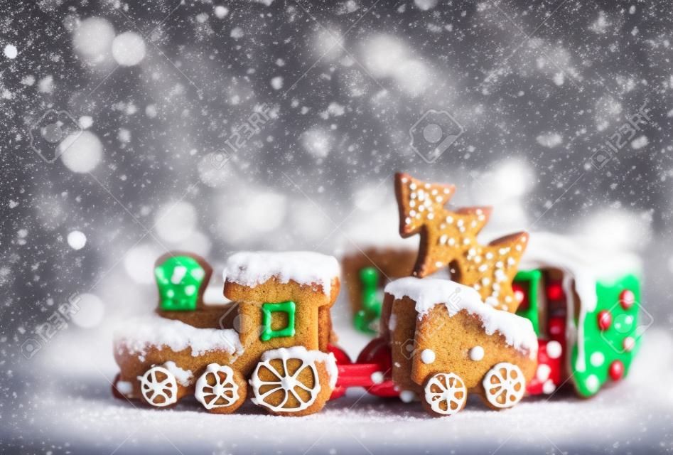 ngerbread Cookies in the form of train. Christmas cookies train covered with icing. Christmas Holidays sweets Gingerbread Cookies train.  New Year card with snow, Christmas gingerbread cookies train