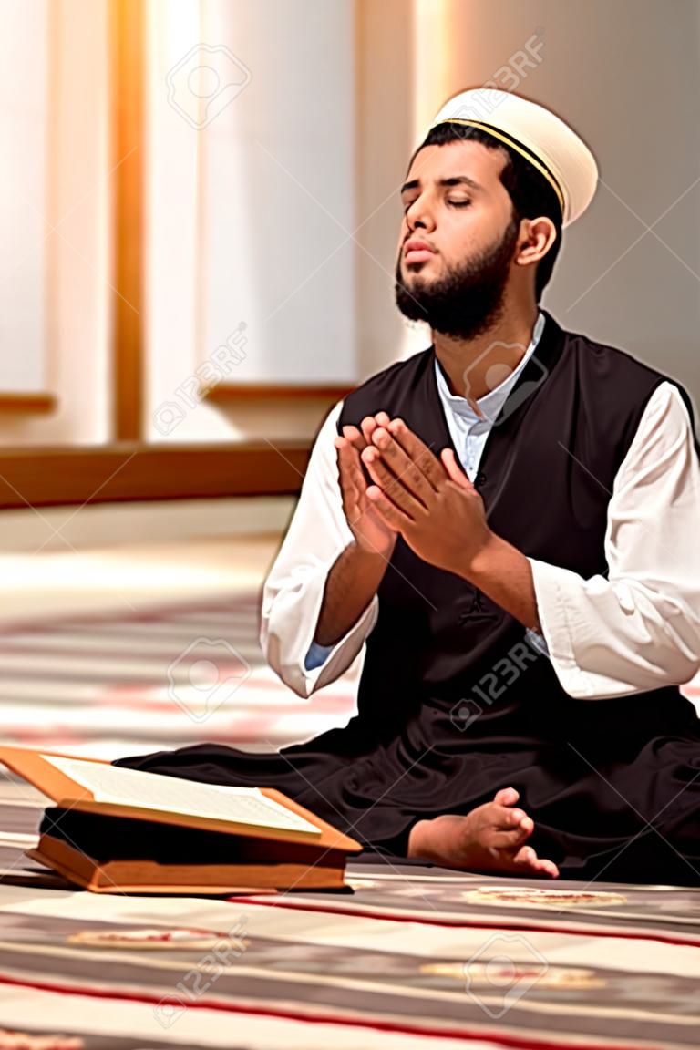 Uomo musulmano religioso che prega dentro la moschea