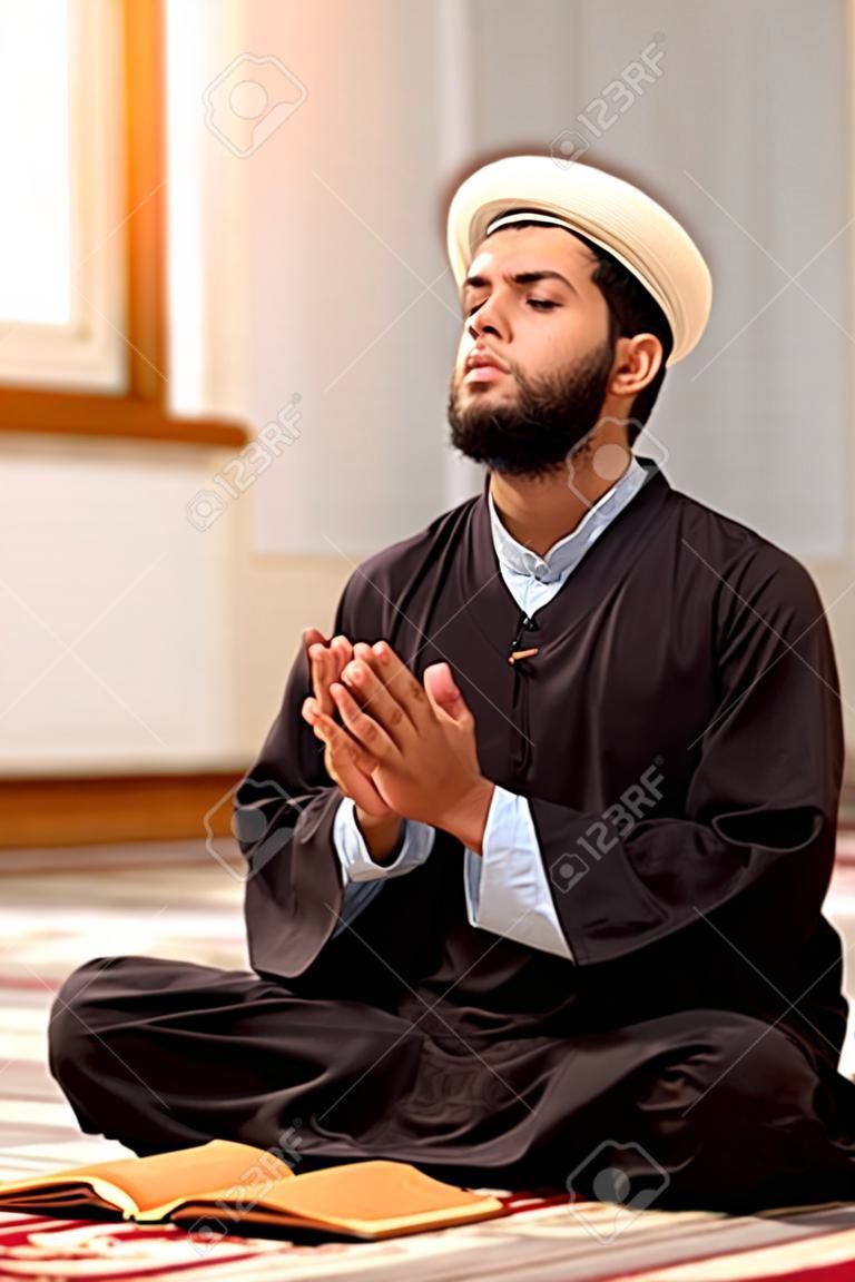 Uomo musulmano religioso che prega dentro la moschea