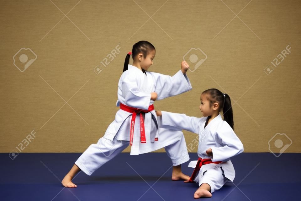 Sztuki walki karate Dwie małe dziewczynki demonstrują wspólnie sztukę walki.