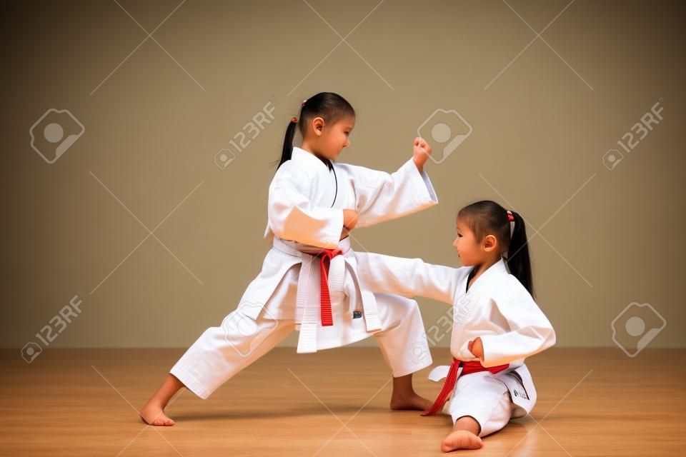 Sztuki walki karate Dwie małe dziewczynki demonstrują wspólnie sztukę walki.