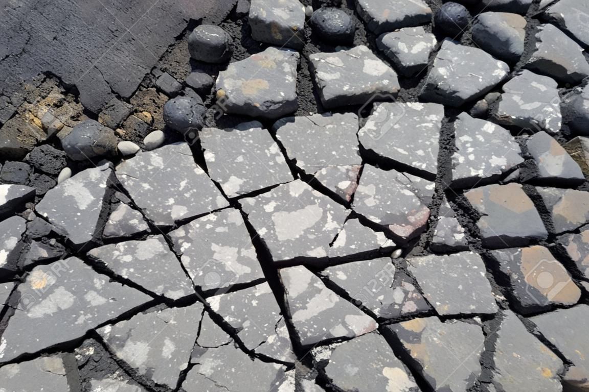 Old asphalt road with many dangerous cracks 