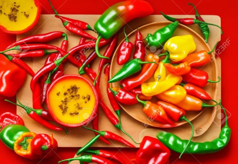 紅色背景上的一組明亮多彩的辣椒。