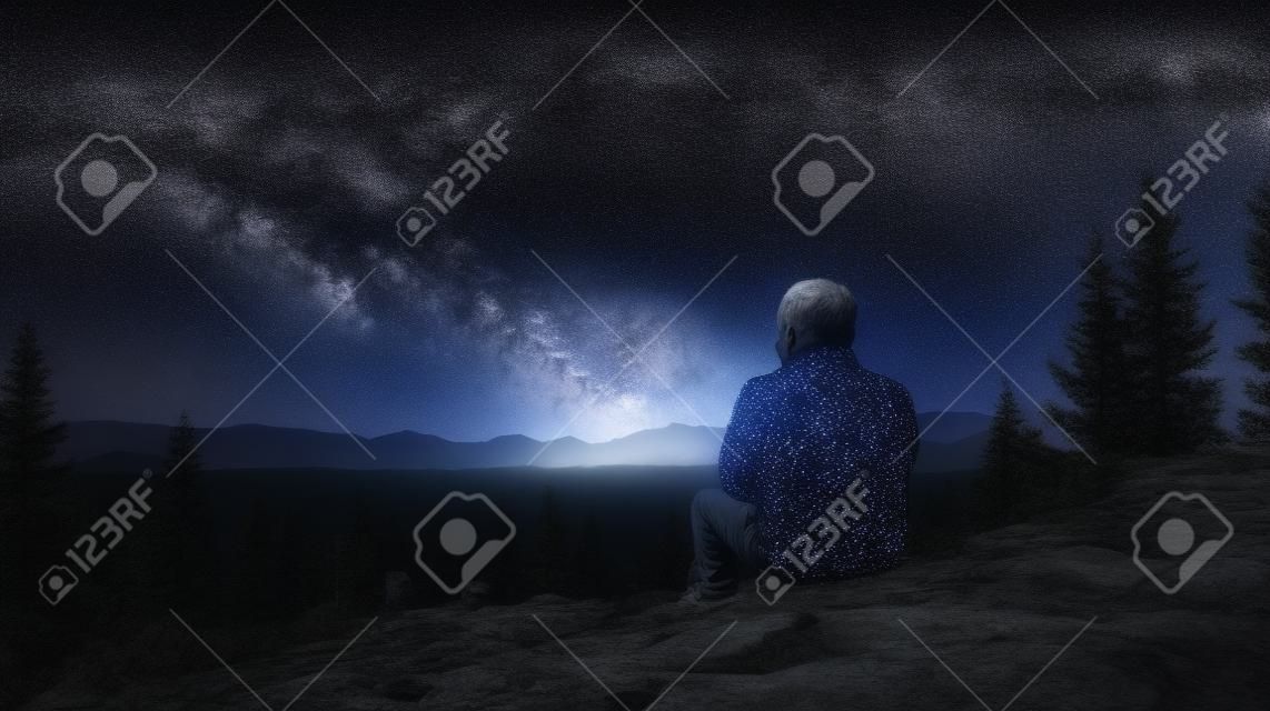 Un hombre sobre una piedra admirando el cielo estrellado generativo ai.
