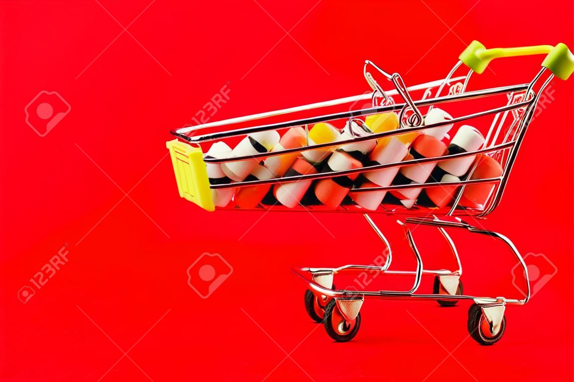 Cart of pills. Red background. Concept: a complete set of medicines in the store. Copy space for text.