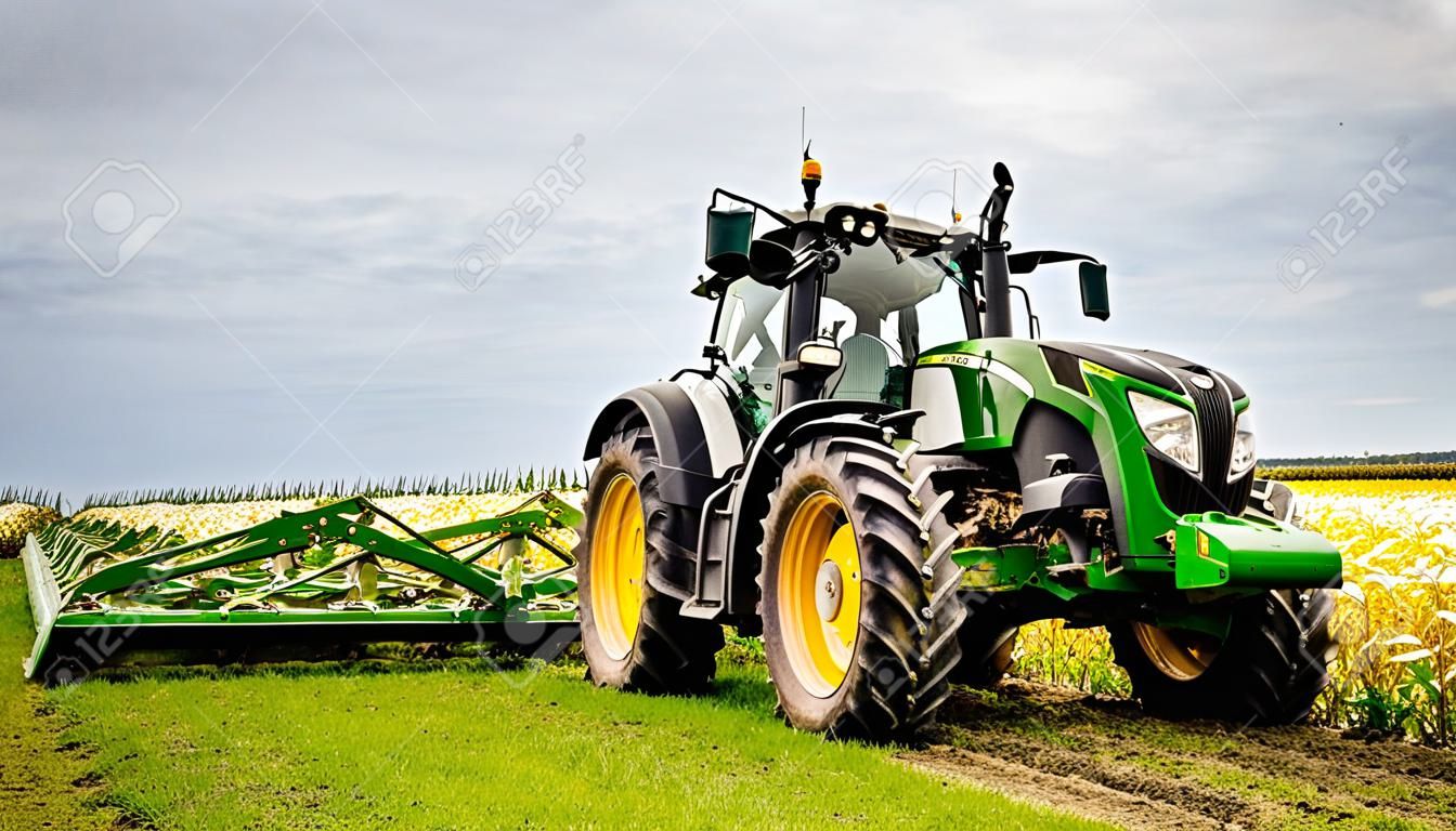Un tractor verde moderno prepara tierras agrícolas con un campo sembrado para el próximo año con la ayuda de equipos y el uso de GPS para agricultura de precisión en los campos.