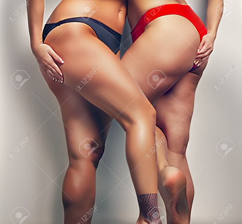 Legs of two woman in swim wear.