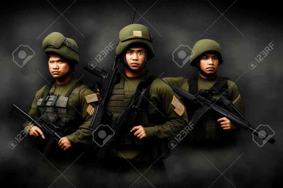 Shot of squad of three soldiers against gray background