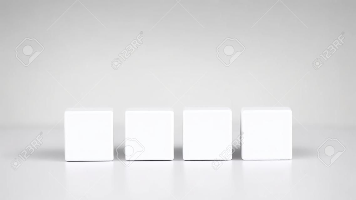 Quatro cubos de madeira em branco ou blocos de construção alinhados em uma linha em uma superfície branca reflexiva com copyspace para o seu texto, letras ou números.