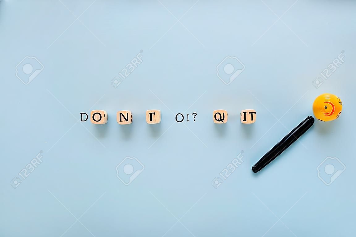 „Don’t quit or do it“-Zeichen auf Holzwürfeln in einem konzeptionellen Bild von Bildung und Karriere. auf blauem Hintergrund.
