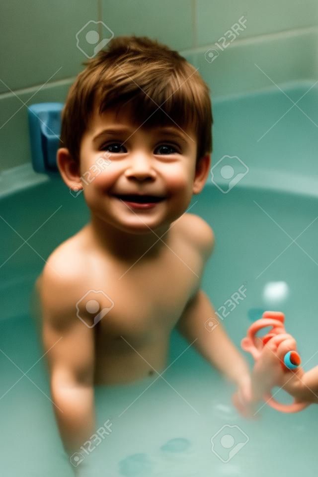 ein kleiner Junge badet im Bad