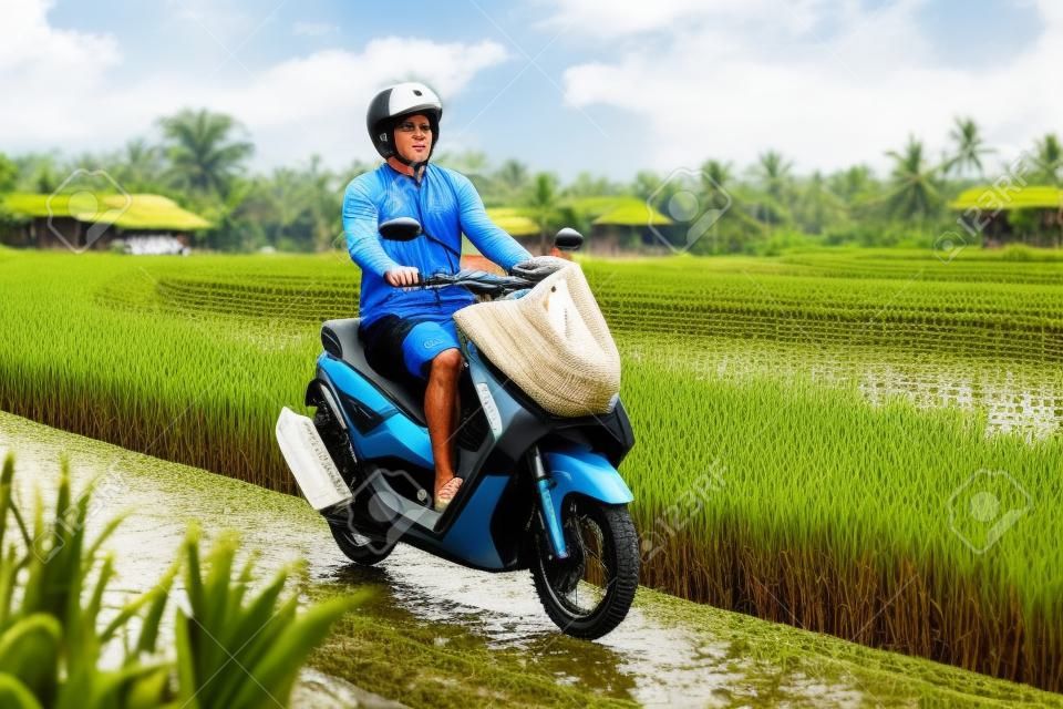 Viajero masculino en bicicleta entre un campo de arroz. Turista viaja a Bali