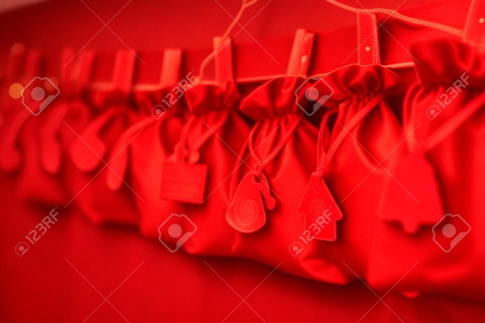 Advent calendar red bags on a rope hang on a childs bed