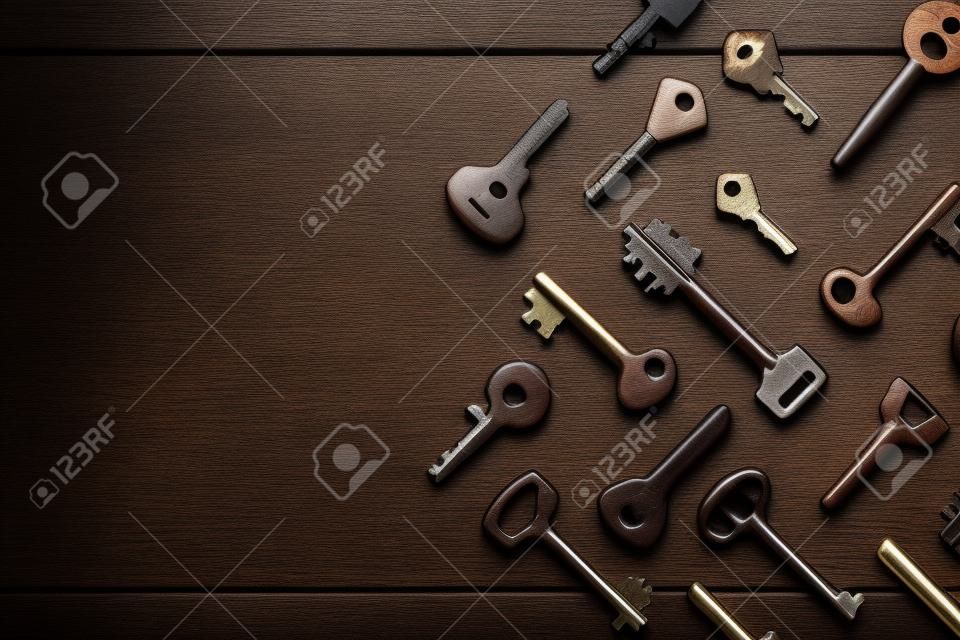 много различных ключей на коричневый деревянный фон с копией пространства