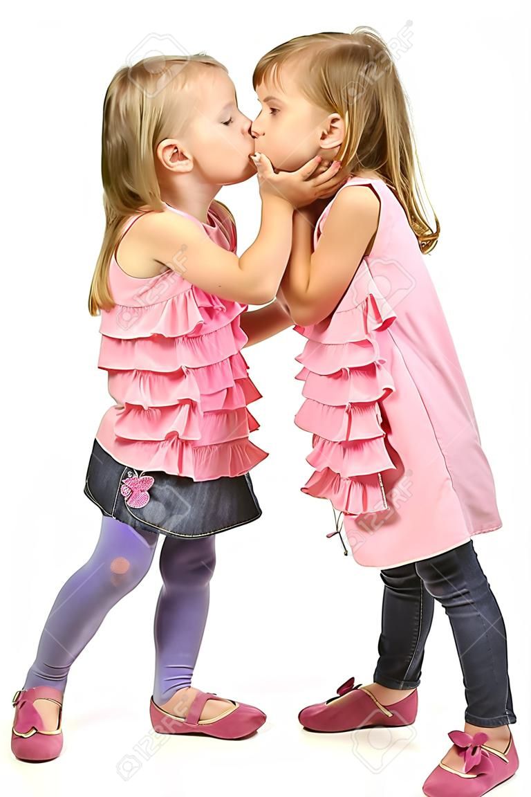 Due bambine che si baciano. Isolato su bianco