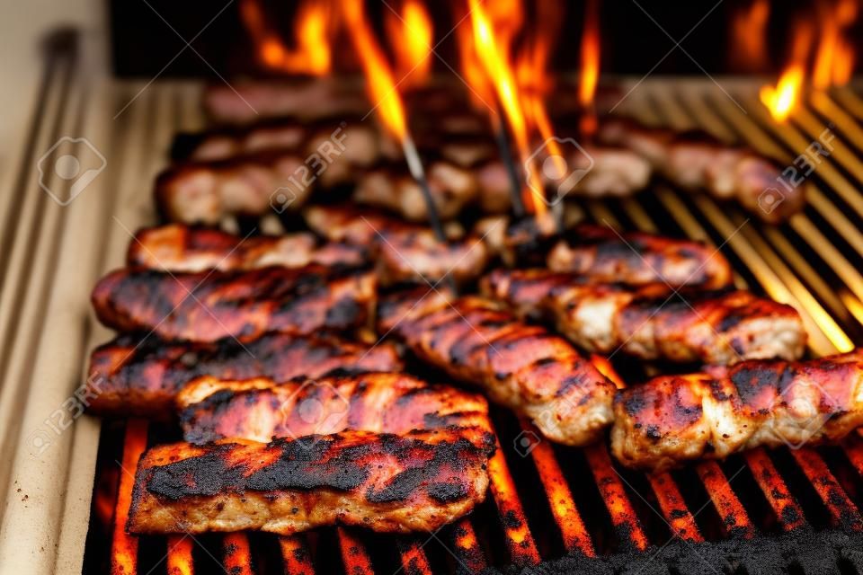 Asar carne a la parrilla con carbón caliente. Preparar, cocinar cevapcici, kebabs, salchichas campestres en barbacoa de carbón Barbacoa en la chimenea exterior. Comida tradicional turca, bosnia, serbia, croata