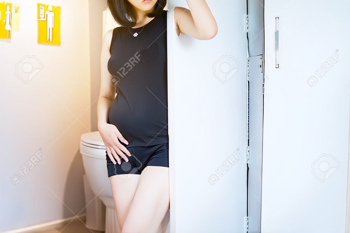 Рука азиатская женщина, держащая ее промежность, женщина должна пописать в туалет