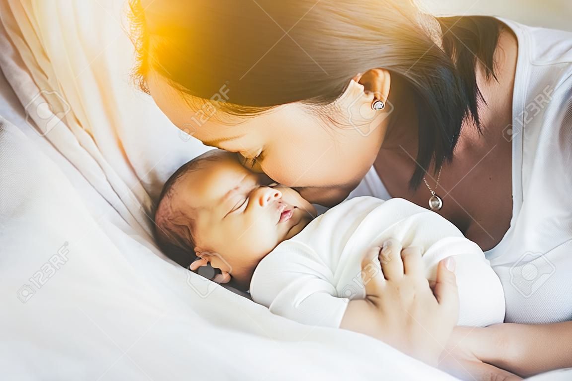 Mother kissing on forehead newborn baby boy,Loving mom with infant