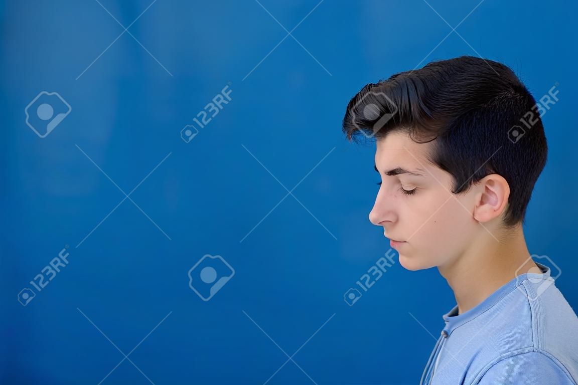 Retrato de un hombre rebelde adolescente con un fondo azul