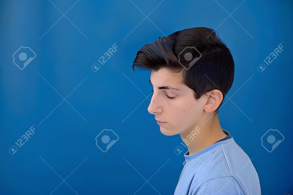 Retrato de un hombre rebelde adolescente con un fondo azul