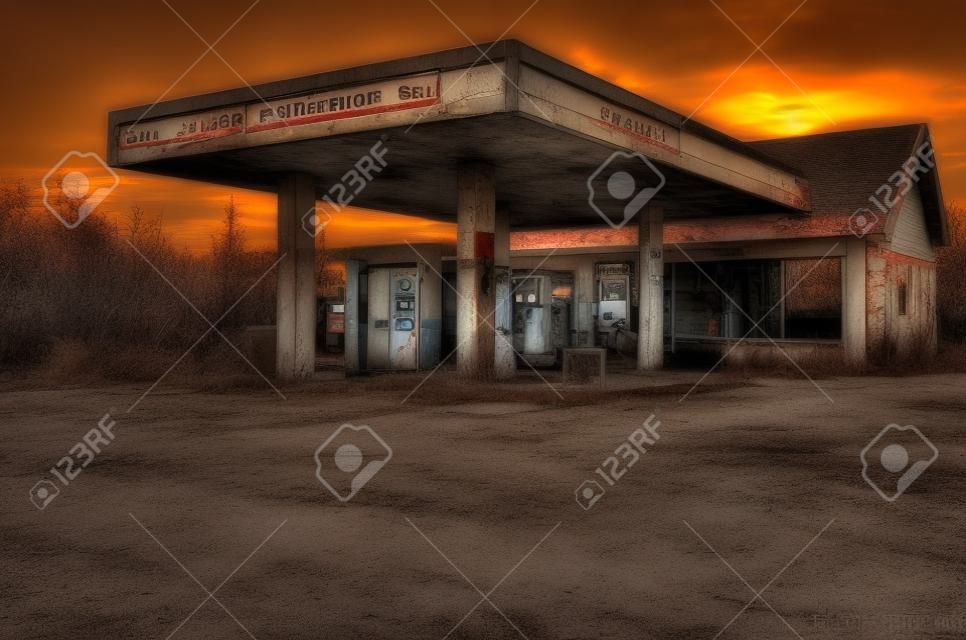 Abandonado velho posto de gasolina, pôr do sol no fundo.